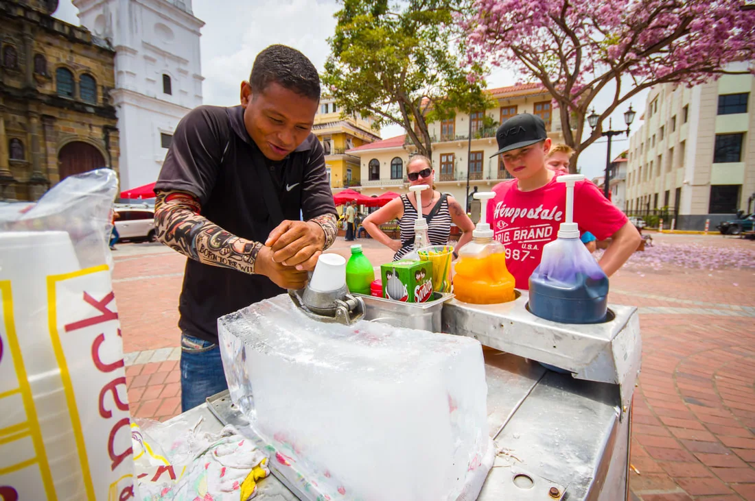 Vendedor preparando un raspado en su carrito, en una plaza del Casco Antiguo