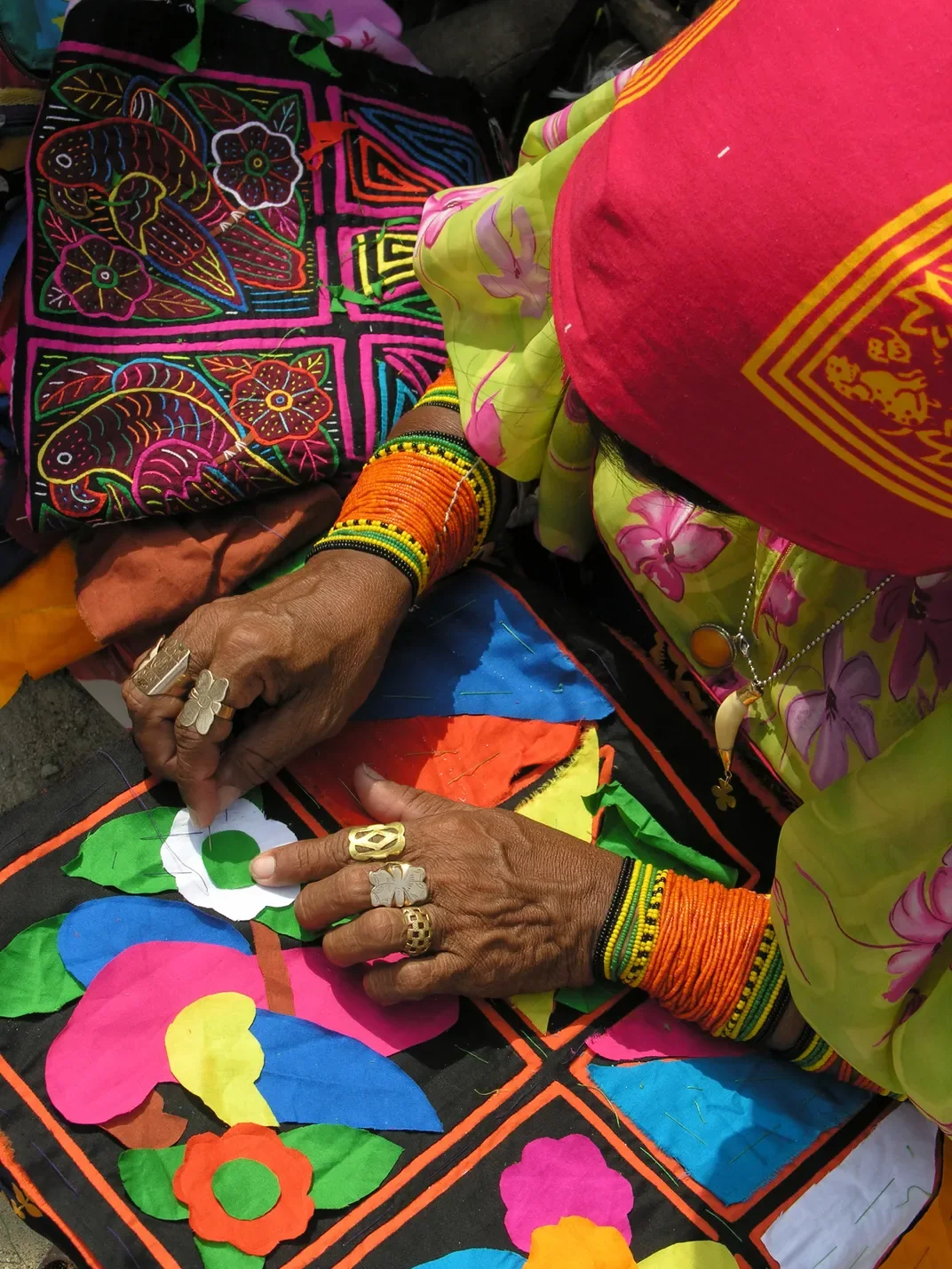 Manos de una artesana guna cosiendo una mola de colores